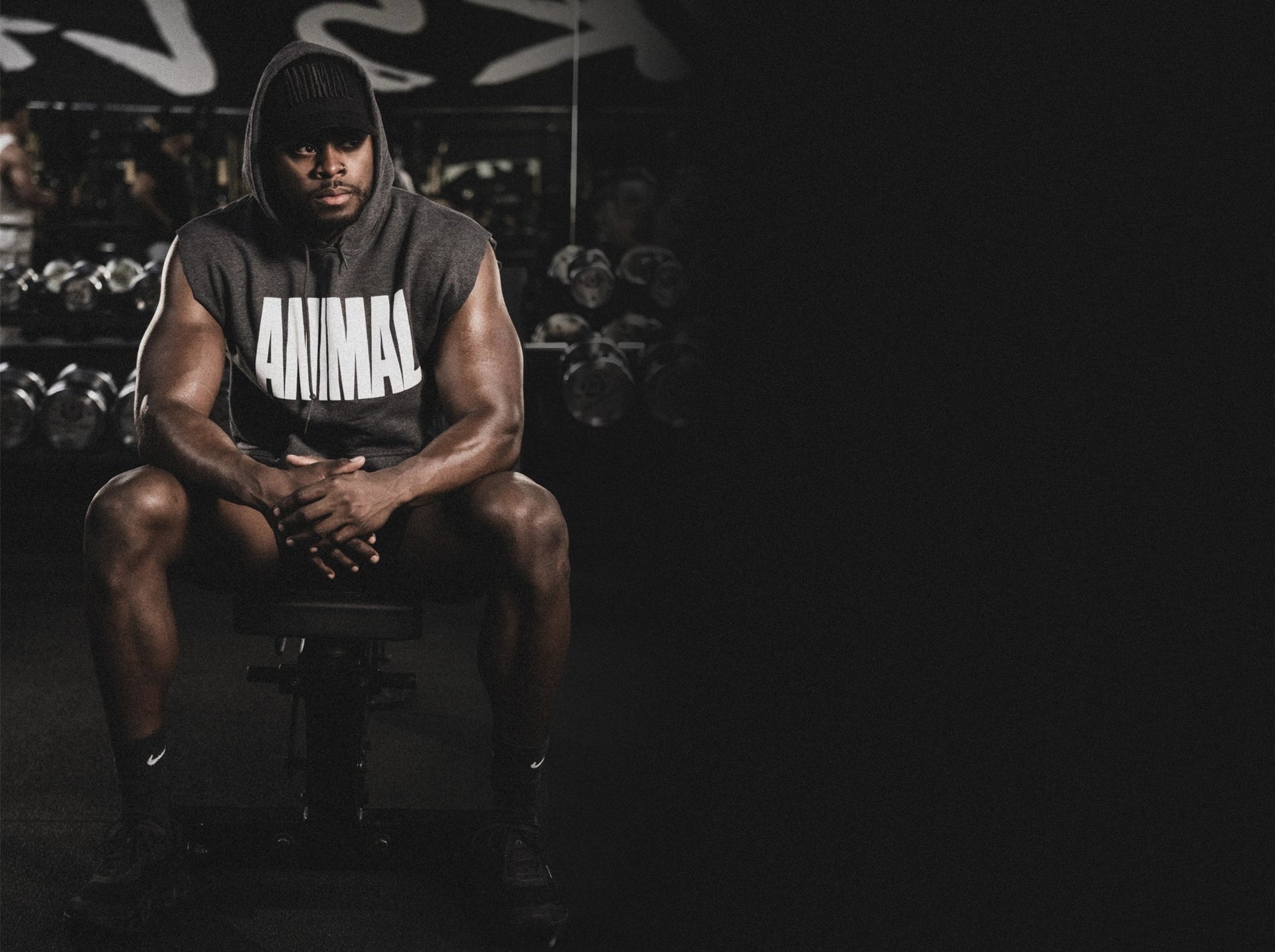 Athlet, der ein Animal-Shirt trägt, sitzt in einem Fitnessstudio